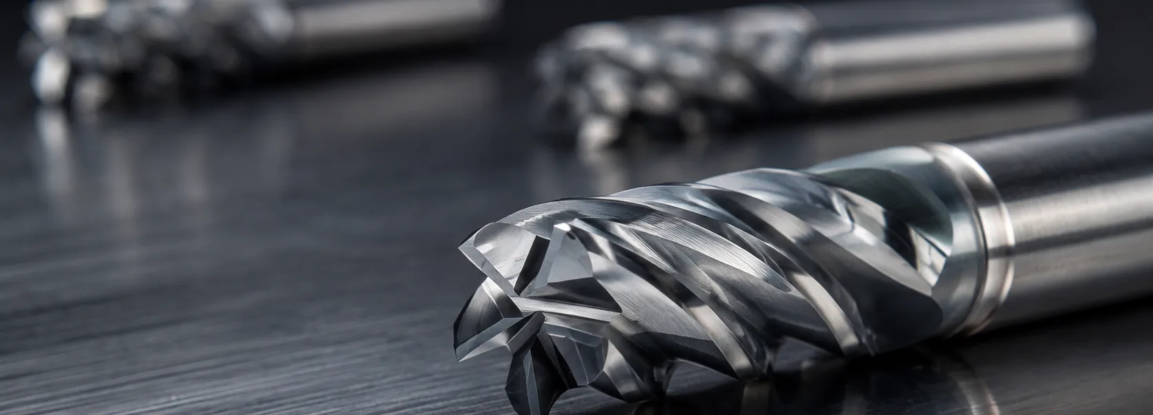 Original EUROCUTPRECISION Z5 five-flute cutting tool, with two tools behind on a dark machined surface